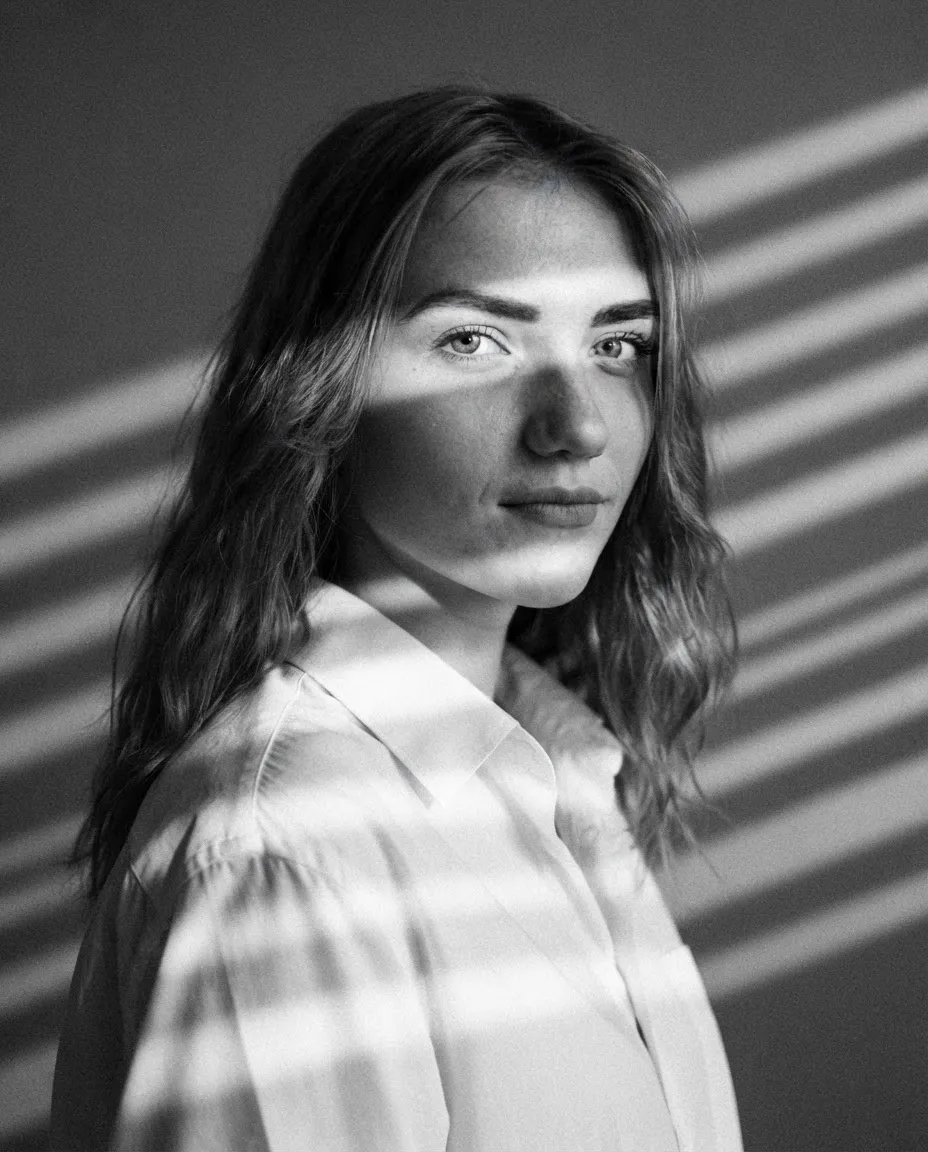 Studio portrait with hard venetian blind shadow stripes falling across the face and backdrop