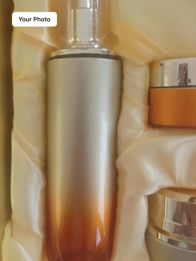 Plain phone photo of two cosmetic bottles on a cream cloth