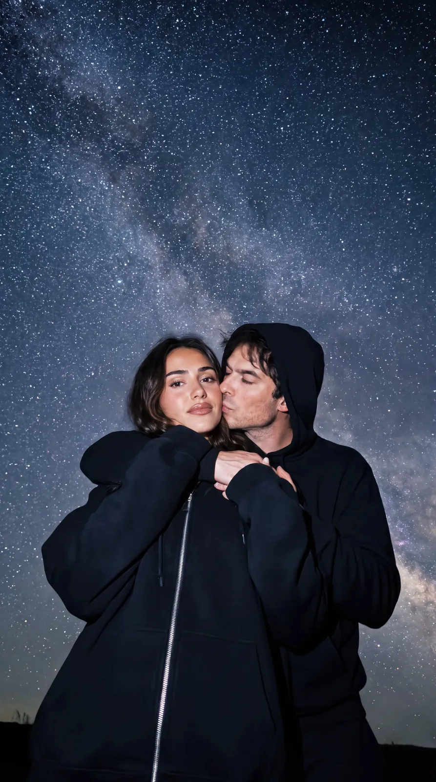 Couple embracing under the Milky Way at night, the man leaning into the woman's cheek
