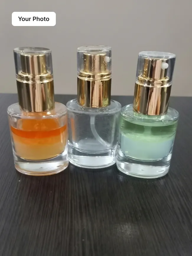 Plain phone photo of three skincare bottles with gold pumps on a dark table
